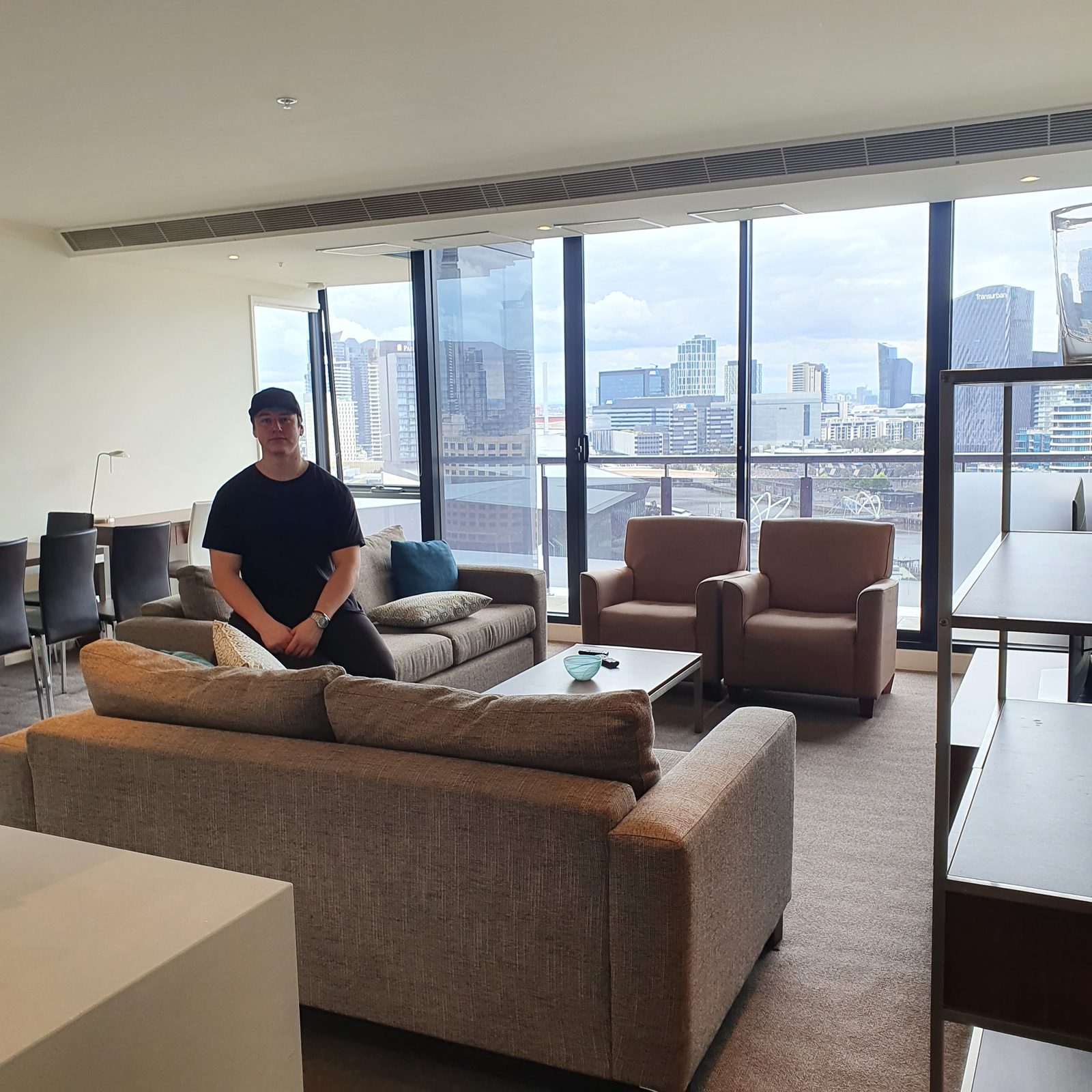Lachie in his first high-rise apartment overlooking the Melbourne skyline