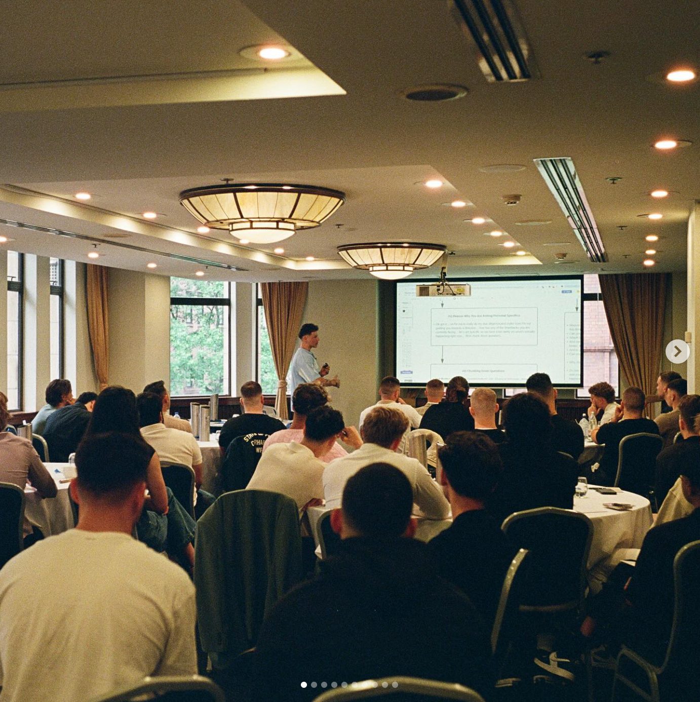 Lachie Pior speaking on stage at a sales conference in Sydney